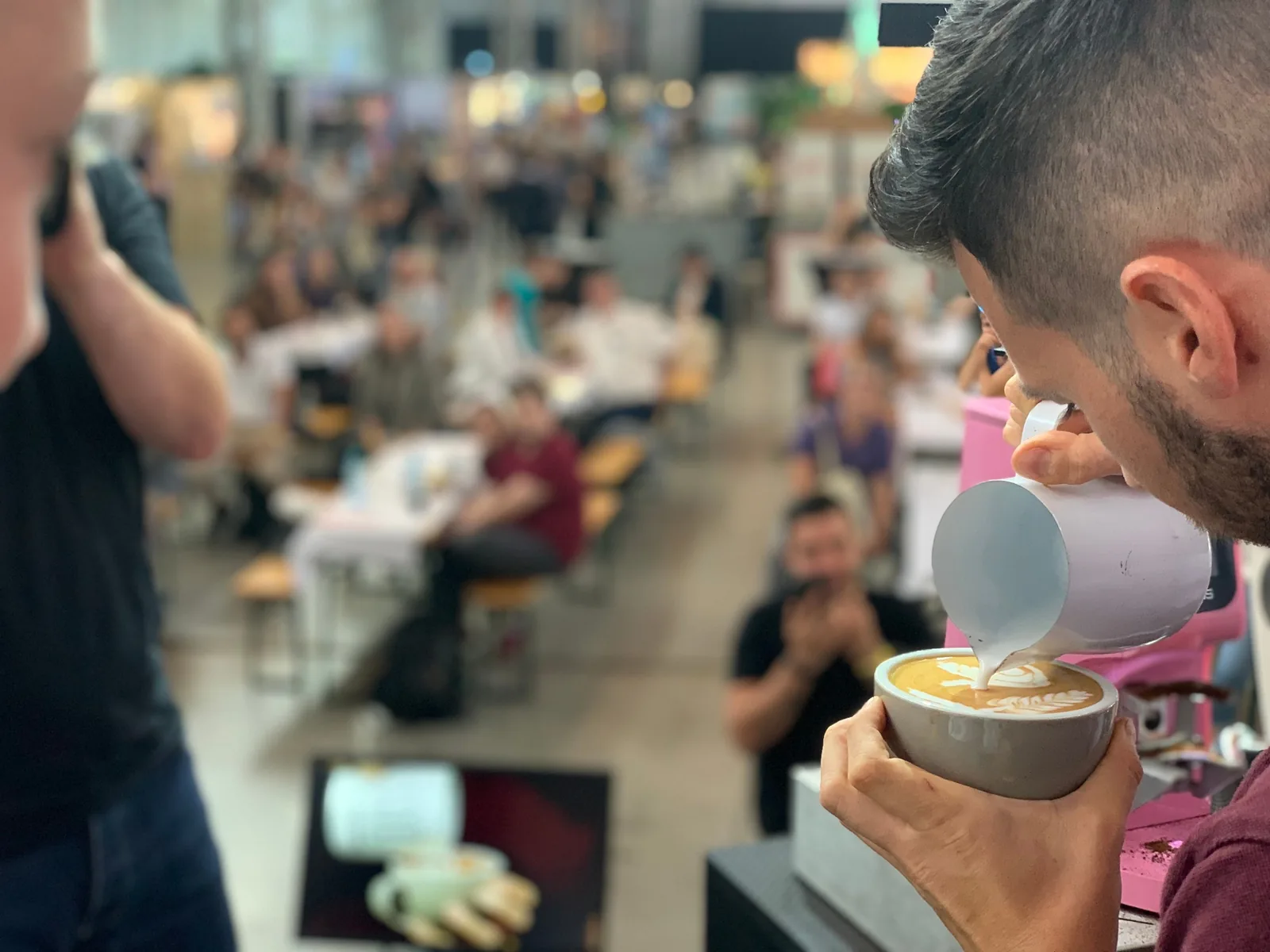 Matteo Beluffi versa una latte art davanti al pubblico durante uno show